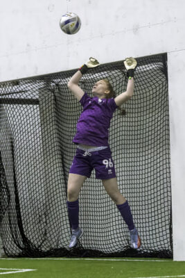 Female goalie attempting to save ball
