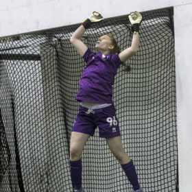 Female goalie attempting to save ball
