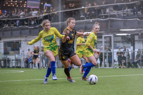 One Columbus Eagles female soccer player takes on multiple opposing team members