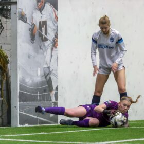 Goalie dives to stop goal during women's soccer game
