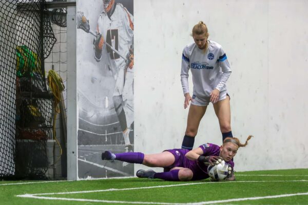 Goalie dives to stop goal during women's soccer game