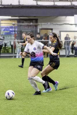 Two opposing players try to get control of ball during women's soccer game
