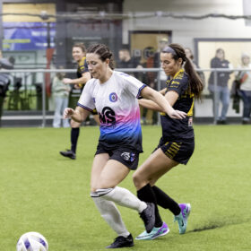 Two opposing players try to get control of ball during women's soccer game
